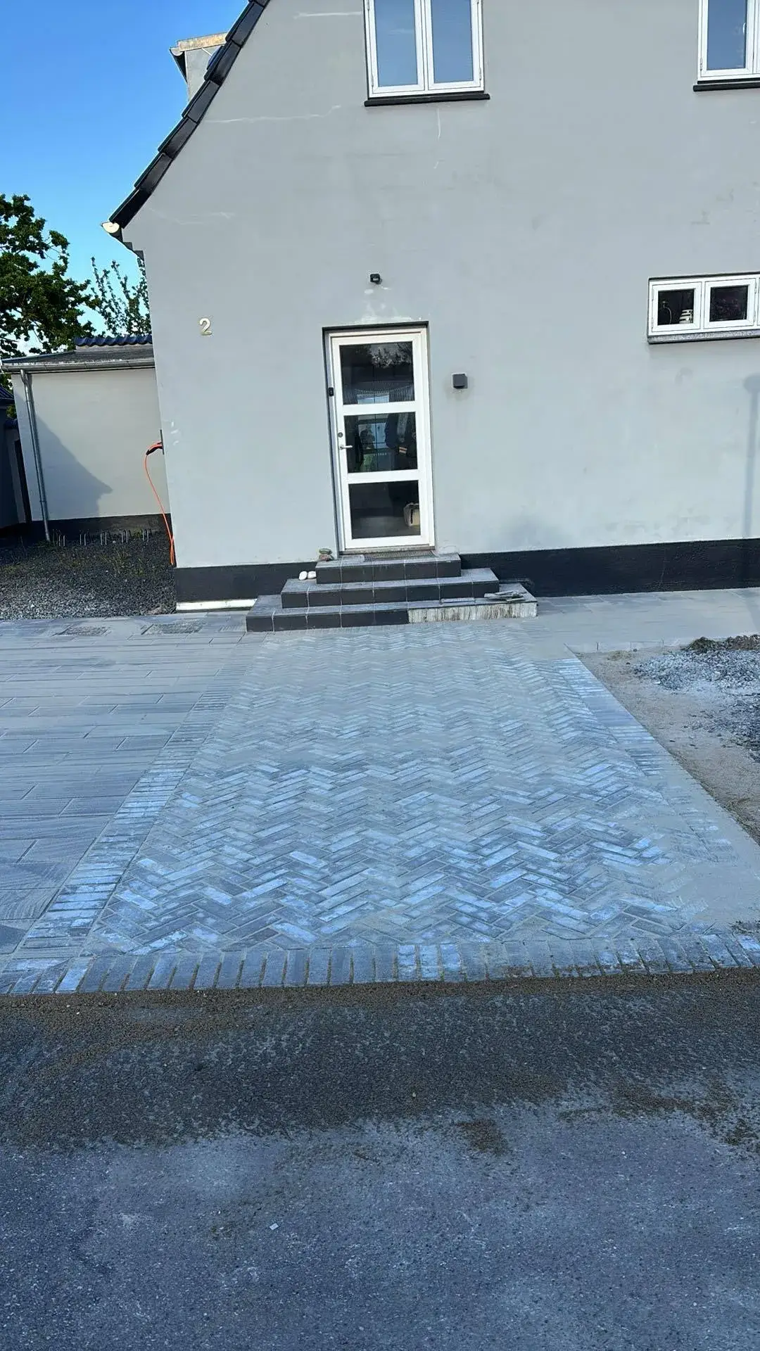 Indkørsel i sildebensmønster ved hvidt hus